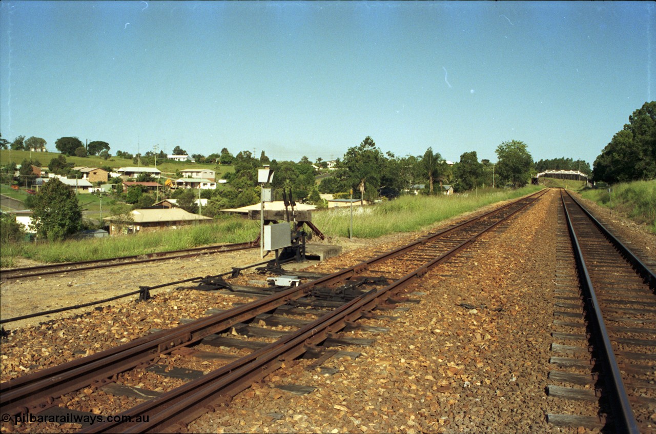 187-14
Monkland, Gympie Queensland. View looking south east in the Up direction, points off loop for yard, footbridge for State School in the distance. [url=https://goo.gl/maps/sKfP96uLv112]GeoData[/url].

