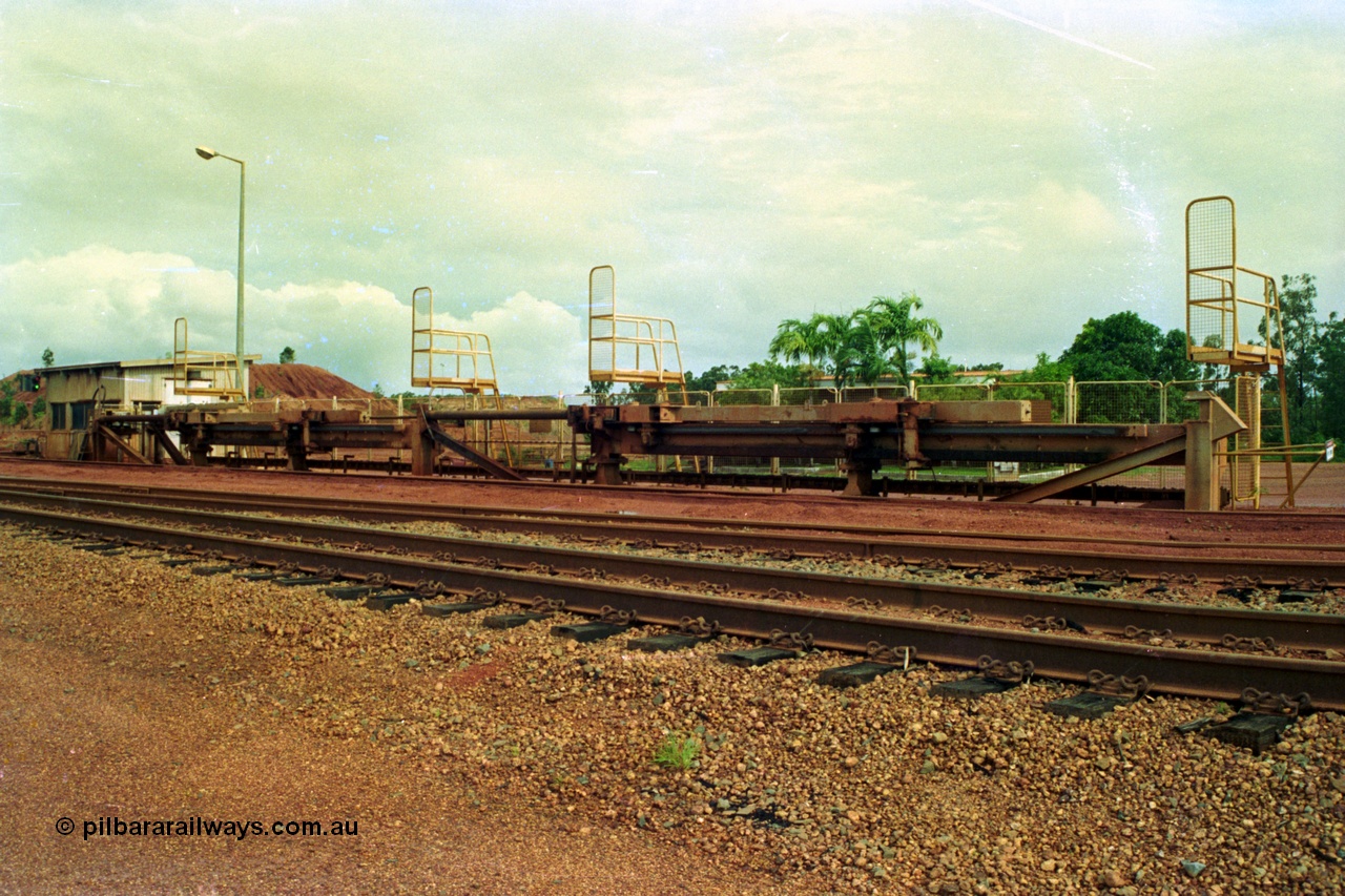 210-01
Weipa, Lorim Point, Comalco rail dump station, view of the hydraulic jacking or indexing arms located on the workshops or empty car side of the unloader, used to position the train for unloading.
