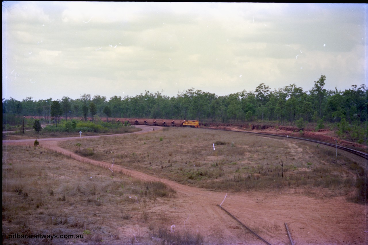 212-18
Weipa, a loaded train from Andoom around the curve as it approaches Lorim Point with thirty or so loaded waggons of bauxite.

