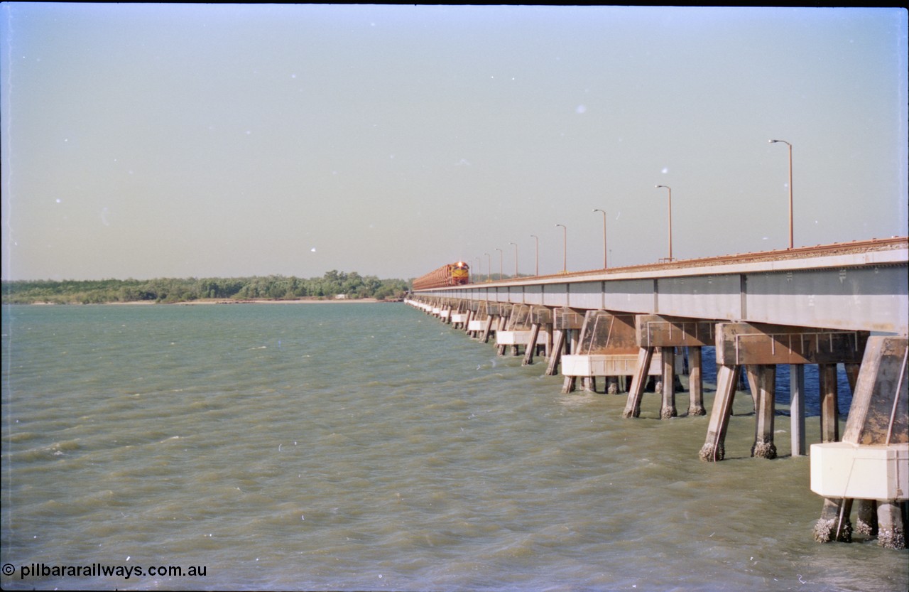 212-28
Weipa, Mission River road and rail bridge from the Andoom and rail side with an empty train headed by Comalco unit R 1004 purchased off BHP Iron Ore in 1994 is a Clyde Engineering built EMD model JT42C built in 1990 with serial 90-1277. July 1995.
Keywords: R1004;Clyde-Engineering-Kelso-NSW;EMD;JT26C;90-1277;Comalco;GML10;Cinderella;GML-class;