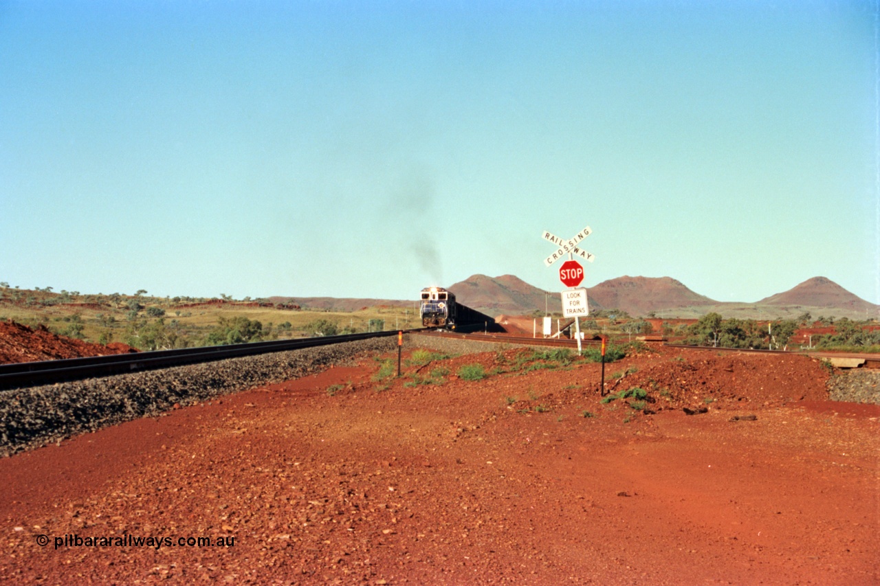 229-00
Yandi Two balloon switch looking east with the Three Sisters forming the background. Empty BHP train heading for the balloon loop for loading, grade crossing is the YT 311.5 km. [url=https://goo.gl/maps/DcycDGojcBt]GeoData[/url].
