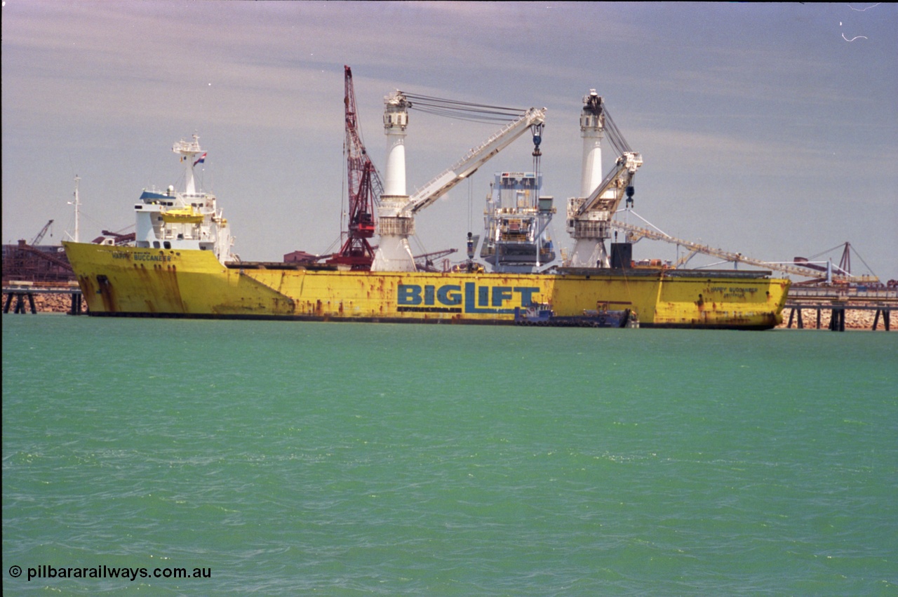 238-03
Port Hedland Harbour, heavy lift ship Happy Buccaneer (IMO: 8300389) sits at Finucane Island D Berth delivering a new shiploader for BHP Billiton. 1st November 2003. [url=https://goo.gl/maps/vWZoHTsRPsp] Geodata [/url]. Back in time here the ship cranes were only 550 tonne each, these are now 700.
Keywords: Happy-Buccaneer;Hitachi-Shipbuilding-Osaka-Japan;