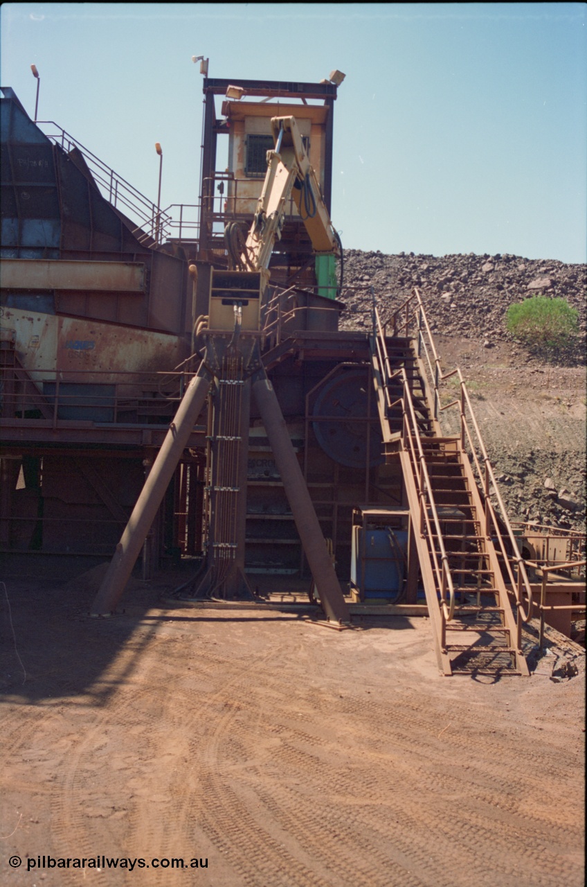 239-19
View of the Yandi One primary crusher or 'mouth of the OHP' from the south side. The Jaques grizzly screen GS01 and Jaques single toggle jaw crusher are visible along with the Transmin rock breaker for when the ROM is oversize. The cab has bars on the window to prevent 'fly-rock' from smashing it. The job of the operator is a lonely one with only the momentum on the swing jaw or the occasional sparky visit to break the monotony. [url=https://goo.gl/maps/HNiykeyX4kD2]GeoData[/url].
