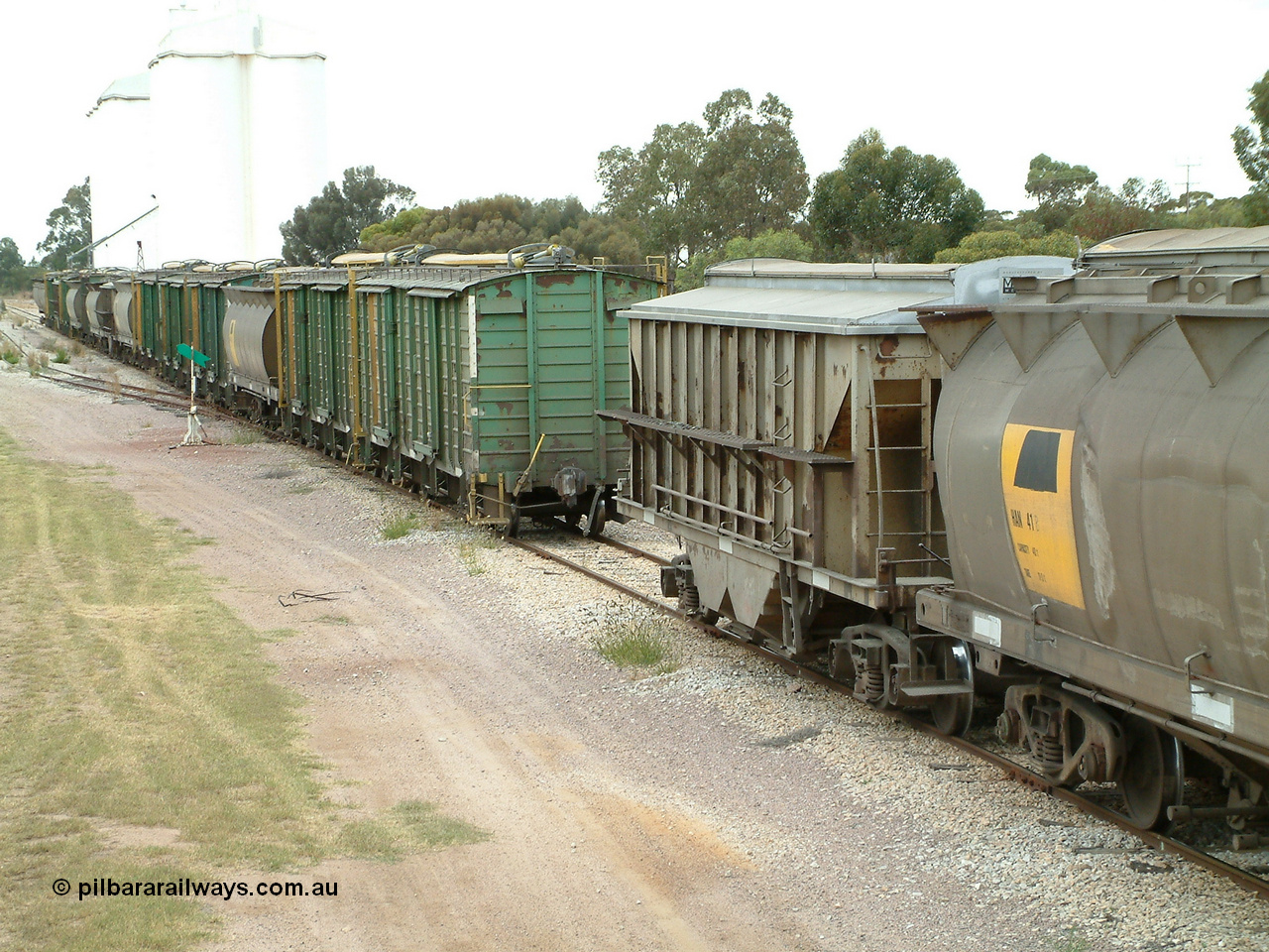 030407 100630
Minnipa, as the front portion shunts away, the make-up of the consist is plain to see. HAN class bogie grain waggon HAN 41, a HBN bogie grain - ballast waggon, and then a motley collection of ENHV, HAN, HBN, HCN and ENHG to round out the consist. 7th April, 2003.
