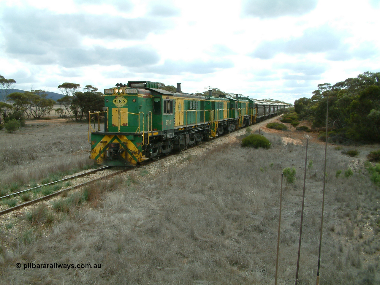 030409 115600
Darke Peake, at the 195 km Dog Fence Road grade crossing loaded grain train with 830 class unit 851 AE Goodwin ALCo model DL531 serial 84137, 851 has spent its entire operating career on the Eyre Peninsula, leads fellow 830 class 842 serial 84140 and a rebuilt unit DA 4, rebuilt from 830 class unit 839 by Port Augusta Workshops, retains original serial 83730 and model DL531 with the first twelve waggons behind the locos XNW type.
Keywords: 830-class;851;84137;AE-Goodwin;ALCo;DL531;