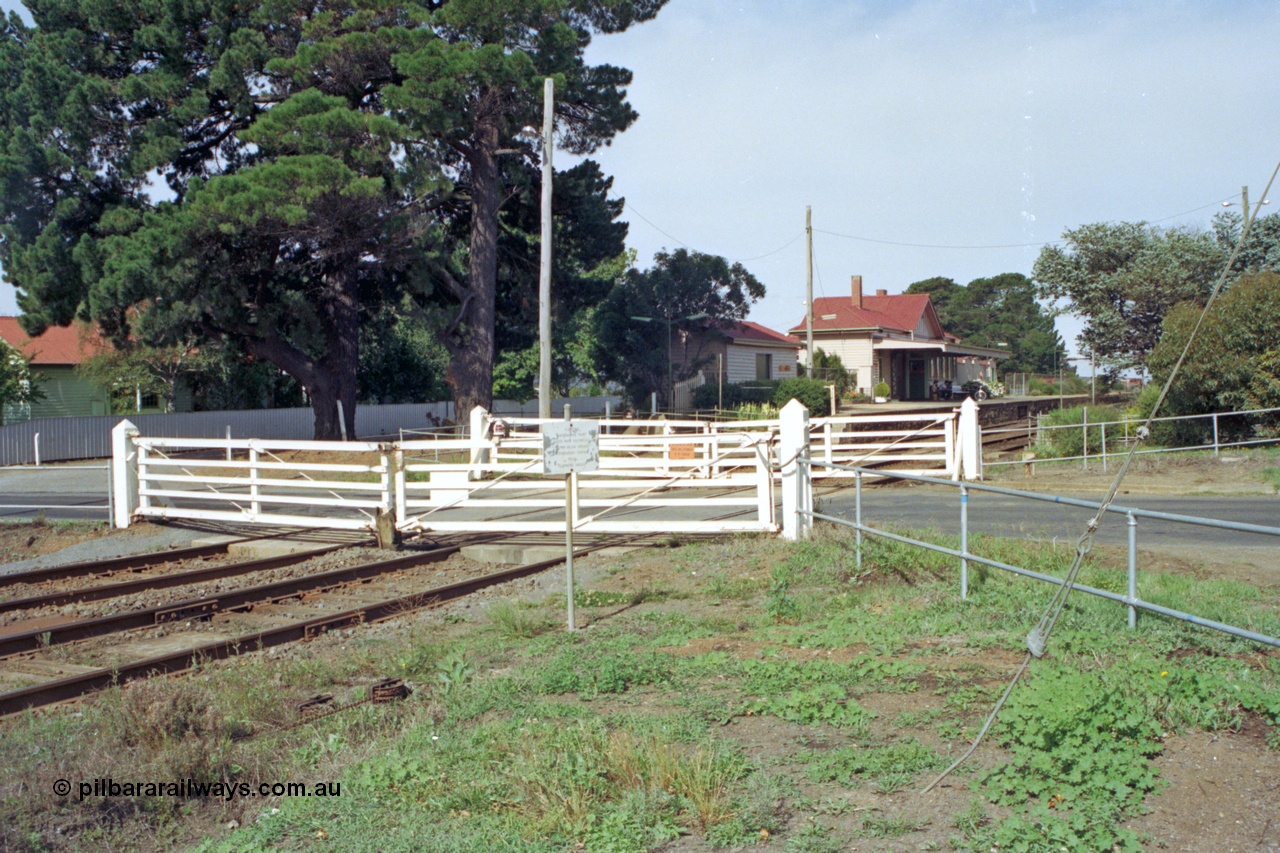 128-17
Gisborne, Gisborne Road grade crossing non-interlocked swing gates, station building in the background.
