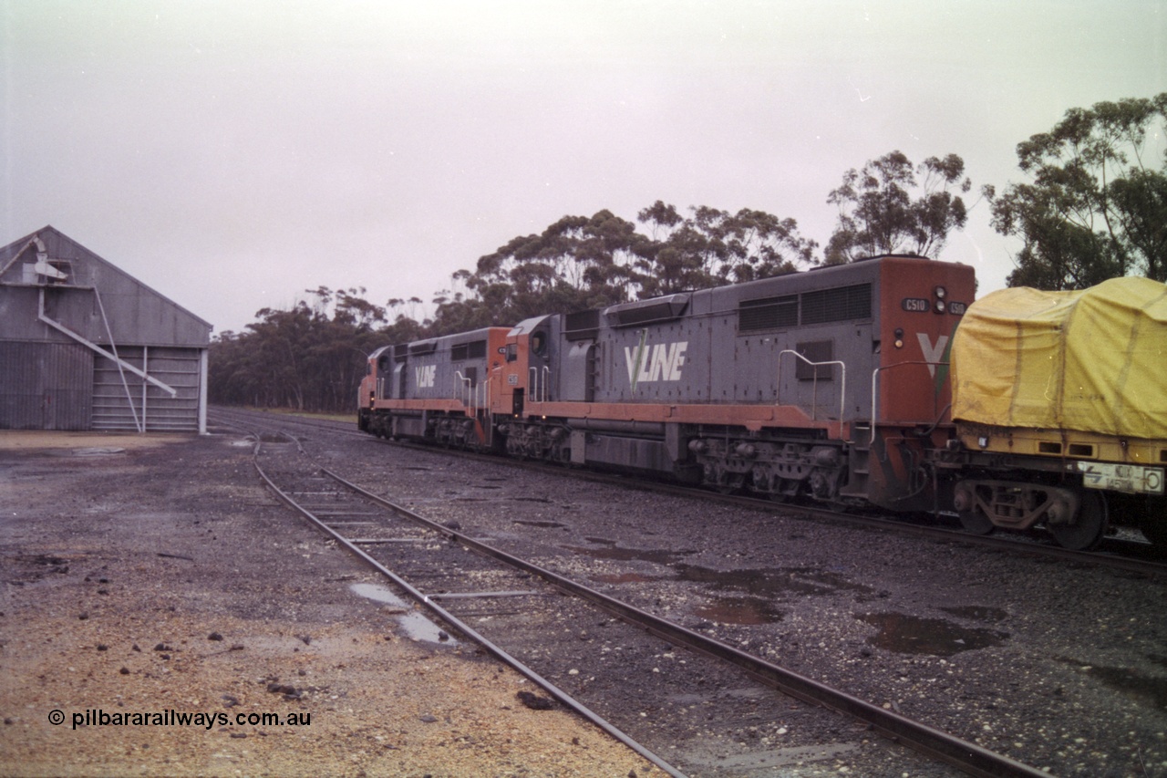 150-17
Lismore, station yard and Victorian Oats Pool bunker, looking towards Maroona from goods loading ramp, V/Line broad gauge C classes C 506 Clyde Engineering EMD model GT26C serial 76-829 and C 510 serial 76-833 leading Adelaide bound goods train 9169 along No. 2 road past the grain bunker, the goods loop or No. 3 road is closest to camera.
Keywords: C-class;C510;Clyde-Engineering-Rosewater-SA;EMD;GT26C;76-833;