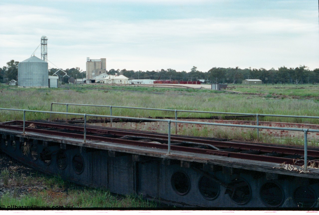 161-32
Tocumwal, overview of the overgrown standard gauge NSWGR yards taken looking south from turntable and pit, silos on the left, derelict flour mill, station building and platform and V/Line broad gauge sleeper transport waggons, standard gauge fettlers shed is at this end of platform.
