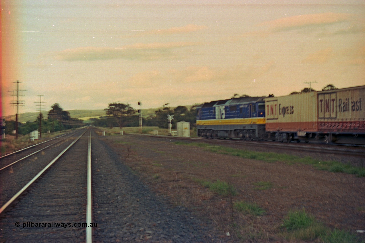 167-10
Wallan Loop, north end, Boundary Rd crossing, standard gauge NSWSRA 81 class 8175 Clyde Engineering EMD model JT26C-2SS serial 85-1094 in new Freight Rail 'Stealth' livery leads its train north across Boundary Road (out of focus), broad gauge tracks on the left.
Keywords: 81-class;8175;Clyde-Engineering-Kelso-NSW;EMD;JT26C-2SS;85-1094;