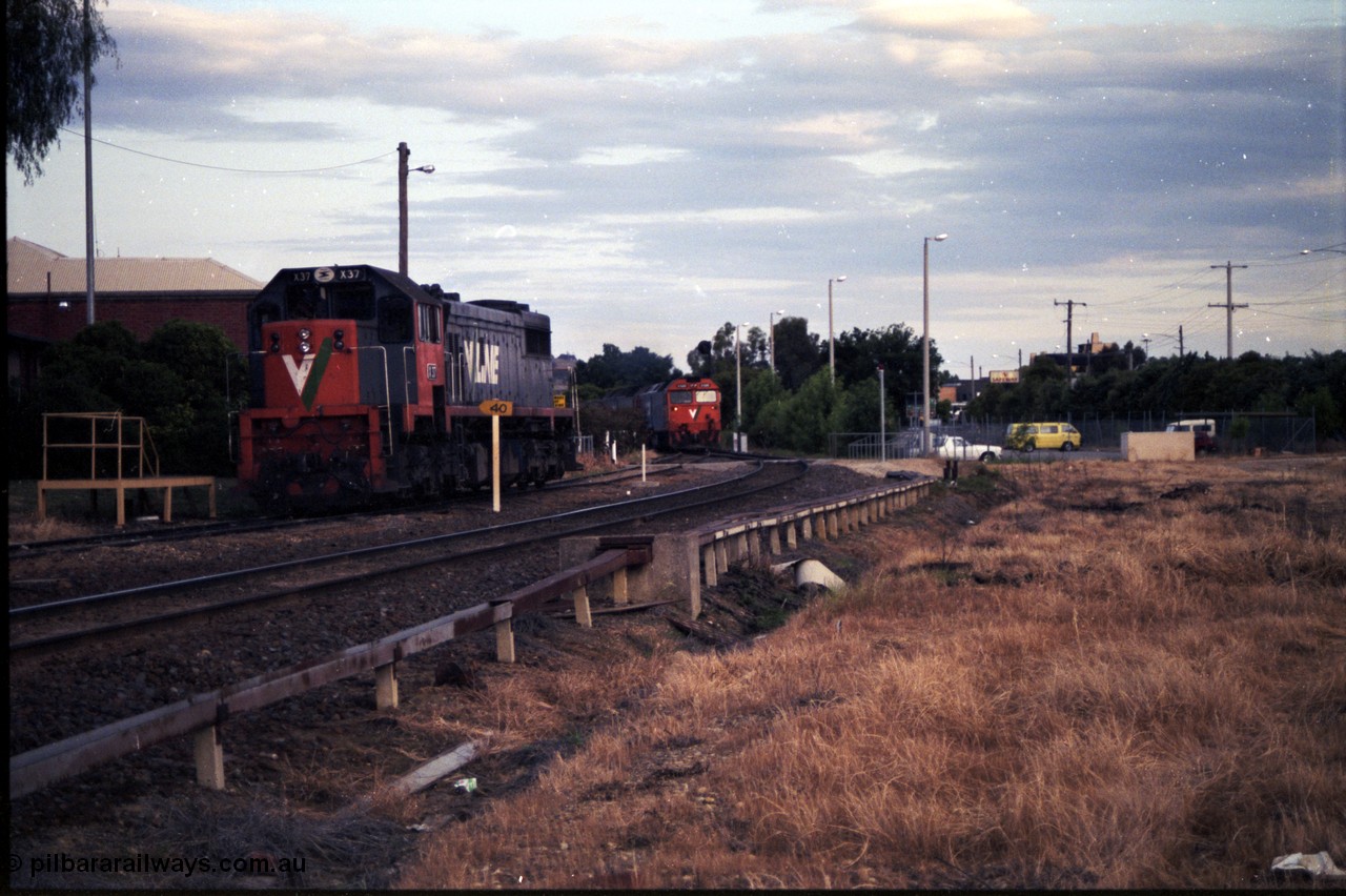 176-21
Wodonga, behind station building, V/Line standard gauge 'stand-by' loco X class 2nd Series leader X 37 Clyde Engineering EMD model G26C serial 70-700 sits in the Diesel Siding, as up Melbourne bound goods train approaches passing the station car park.
Keywords: X-class;X37;Clyde-Engineering-Granville-NSW;EMD;G26C;70-700;
