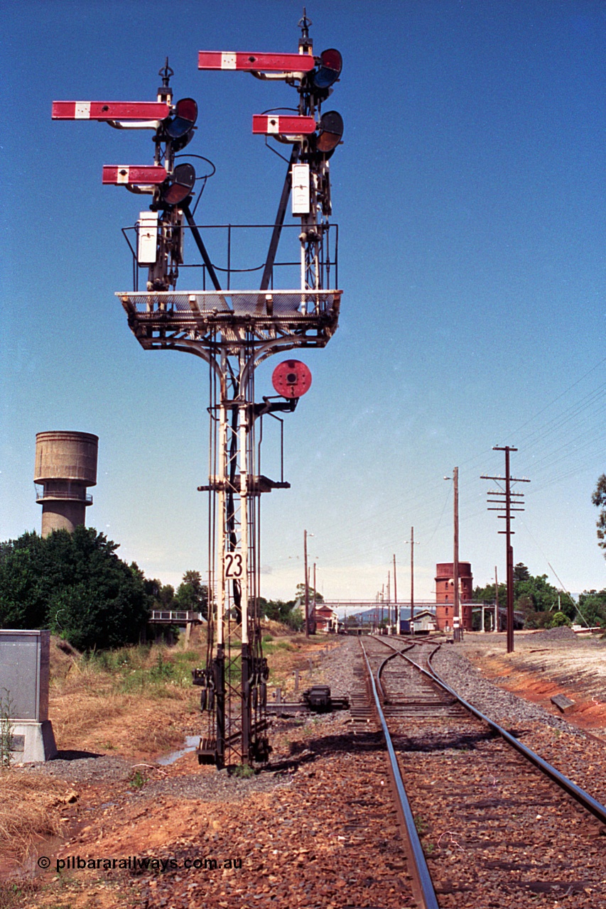 180-10
Wangaratta, yard view looking south past the newly relocated up home semaphore signal post No.23, with new points for Siding 4 (extension of No.3 Road) visible, town water tower and road bridge over the standard gauge line on the left, locomotive water tank, footbridge, goods shed and station building visible in the distance.

