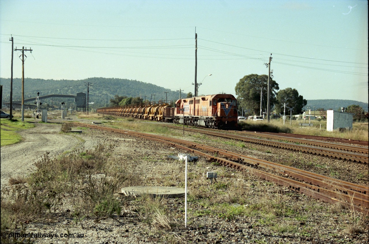 186-13
Midland, Westrail standard gauge up Kalgoorlie loaded acid train 428 crosses Lloyd Street behind a pair of L class locomotives L 258 Clyde Engineering EMD model GT26C serial 68-548 and L 256 serial 67-546, with the dual gauge track to the Flashbutt Yard in the foreground. The empty return working of this train was 027 empty acid.
Keywords: L-class;L258;Clyde-Engineering-Granville-NSW;EMD;GT26C;68-548;