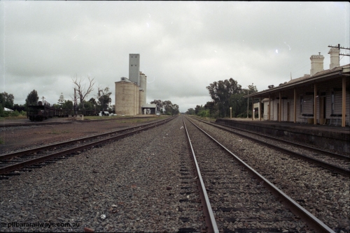 188-02
Culcairn, 596 km from Sydney on the NSW Main South, view of station yard looking north, stored car carrying waggons in grain loop with crane visible in front, station platform and building on the right. Reverse view of 188-01. Geo [url=https://goo.gl/maps/aQzJi3mNY3t]Data[/url].
