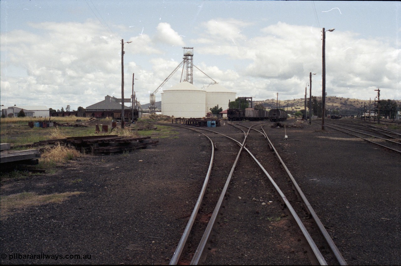 190-10
Cootamundra, NSW Main South, looking south with the grain loading area and Ascom silo complex and the yard with rakes of stored waggons.
