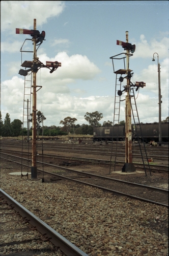 190-08
Cootamundra, NSW Main South, looking from the mainlines across the yard in a north direction, two mechanical lower quadrant semaphore signal posts protect up movements from the yard.
