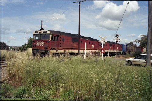 190-24
Cootamundra West, NSW located 431 km from Sydney and the start of the Lake Cargelligo branchline, a Perth bound interstate freight train taking the scenic route, via Cootamundra West, Stockinbingal and Parkes, passes over Yass Road through the manual hand gates behind 81 class locomotive 8159 and a sister unit.
Keywords: 81-class;8159;Clyde-Engineering-Kelso-NSW;EMD;JT26C-2SS;84-1078;