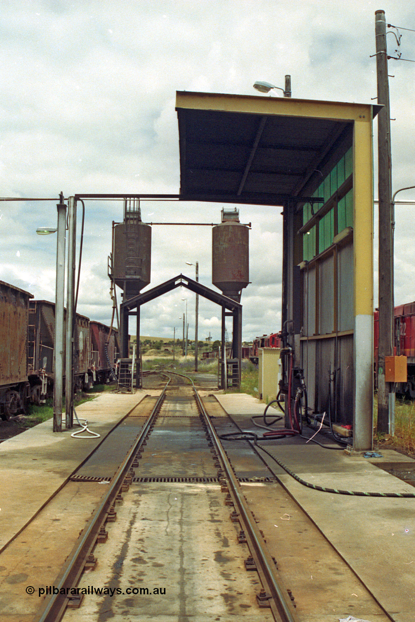 192-14
Junee, NSWSRA standard gauge locomotive depot, a view looking through the fuelling point with the sanding facility behind that, stored 45 class units on the right.
