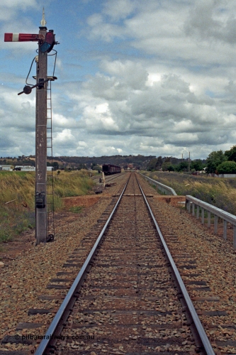 192-25
Cootamundra West, NSW, view looking up direction across Freer's private grade crossing towards Cootamundra West from the up home mechanical lower quadrant semaphore signal on a wooden post and still with finial. Lever 48 operates this signal. The sidings on the left are the Refuge and No.1 Goods Sidings.
