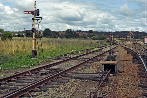 192-29
Cootamundra West, NSW, view of Frame B and metal post mechanical lower quadrant semaphore signal operated by lever 37 is for up moves out of the Refuge or Goods Sidings to the Loop Line. The signal post is reduced in height due to the airfield adjacent to the line.
