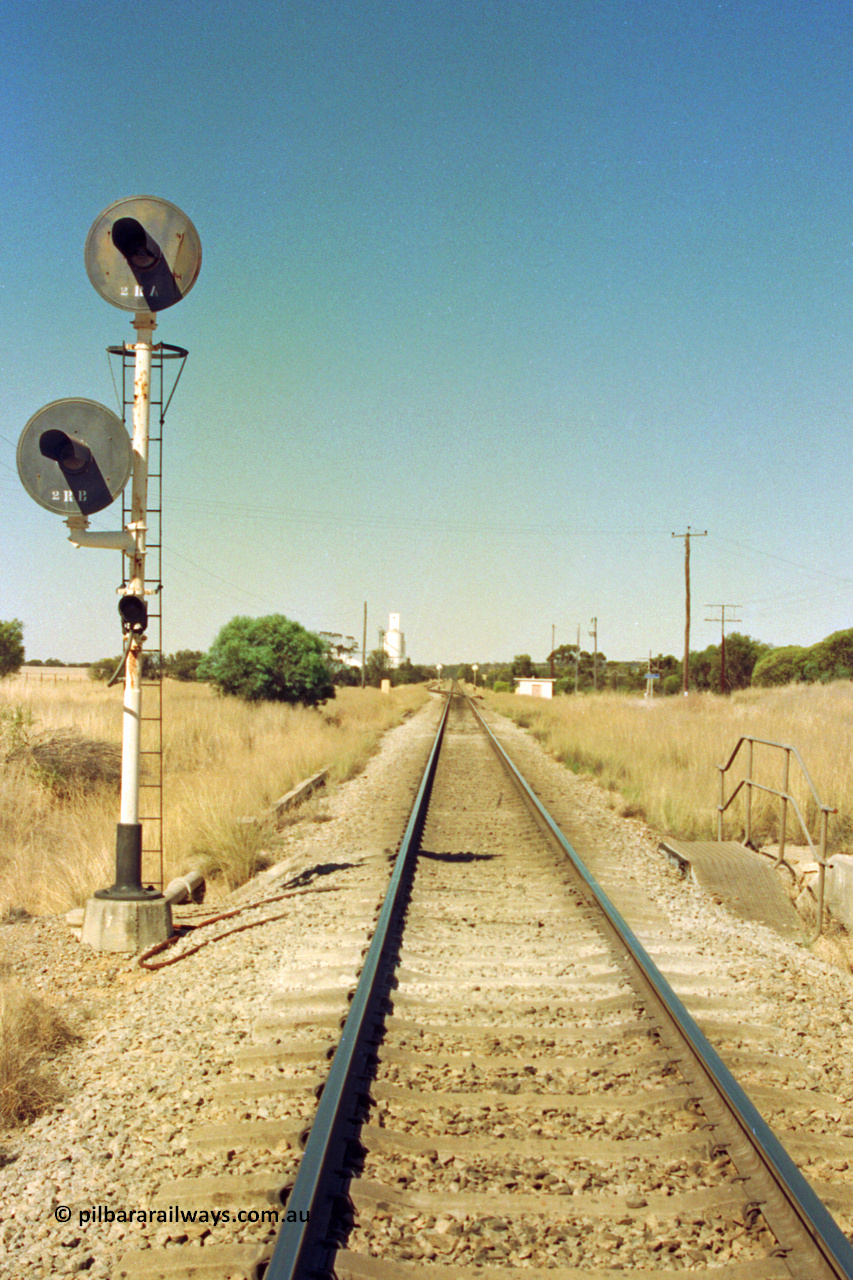 202-06
Meckering, looking east at the Down arrival signal mast, 2 RA and 2 RB, relay room and grain silos in the distance.
