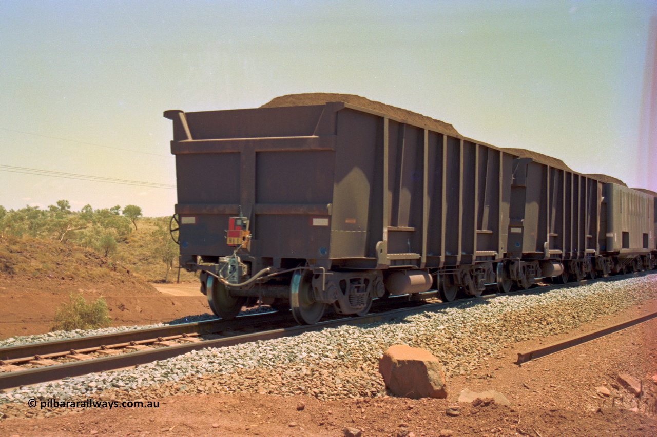 202-33
Yandi One, 307 km grade crossing, the last waggons on a loaded train, the last two are both Comeng style waggons, while the third, also being built by Comeng was originally built as a fixed wheel waggon with four axles, later converted to bogies.
