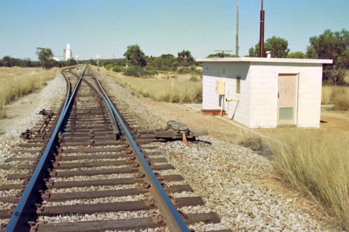 202-07
Meckering, looking east, the points for the crossing loop with dual control point machine and relay interlocking room which houses the backup power plant, silos in the distance.
