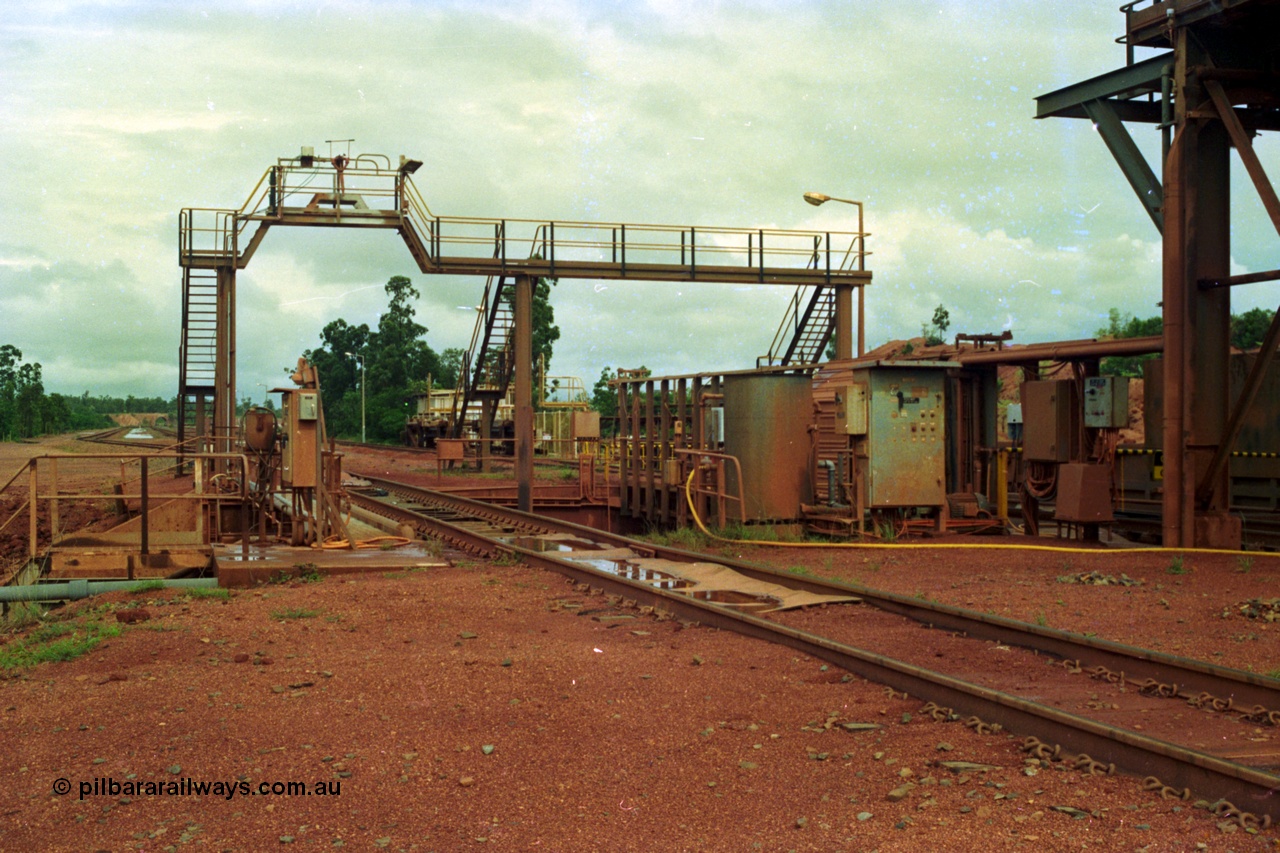 210-02
Weipa, Lorim Point, Comalco rail dump station, view looking towards Andoom Mine, shows inspection walkway and opening for unloading hopper, the waggons are discharged on the right track.
