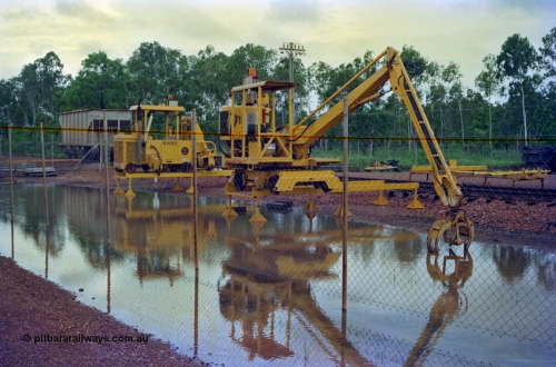 210-17
Weipa, Lorim Point track maintenance compound, sleeper handler crane and a sleeper scarifier - inserter beside it numbered R 4015, ballast waggon R 4003 in the background.
Keywords: Comalco;