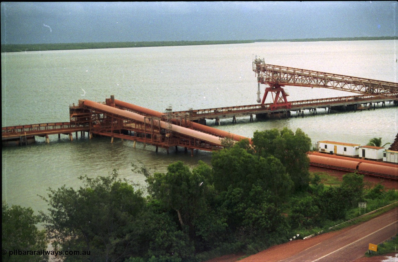 211-04
Weipa, Lorim Point, view of the two loading conveyors running between the stockpiles and wharf, the kaolin loader in on the right hand side of the wharf.
