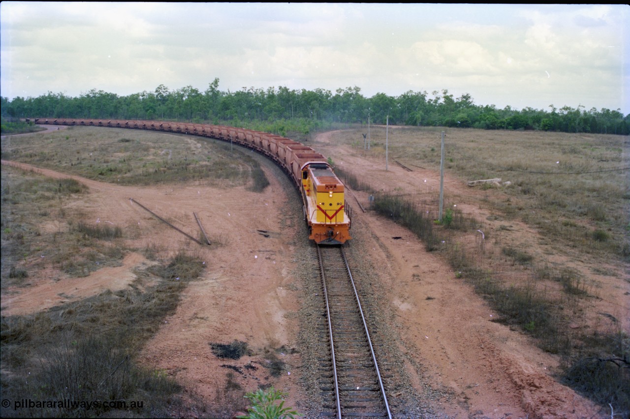 212-20
Weipa, a loaded train from Andoom Mine rounds the curve on approach to Lorim Point behind a long end leading Comalco R 1001 Clyde Engineering built EMD model GT26C serial 72-752 originally numbered 1.001 and built in 1972. July 1995.
Keywords: R1001;Clyde-Engineering;EMD;GT26C;72-752;1.001;Comalco;
