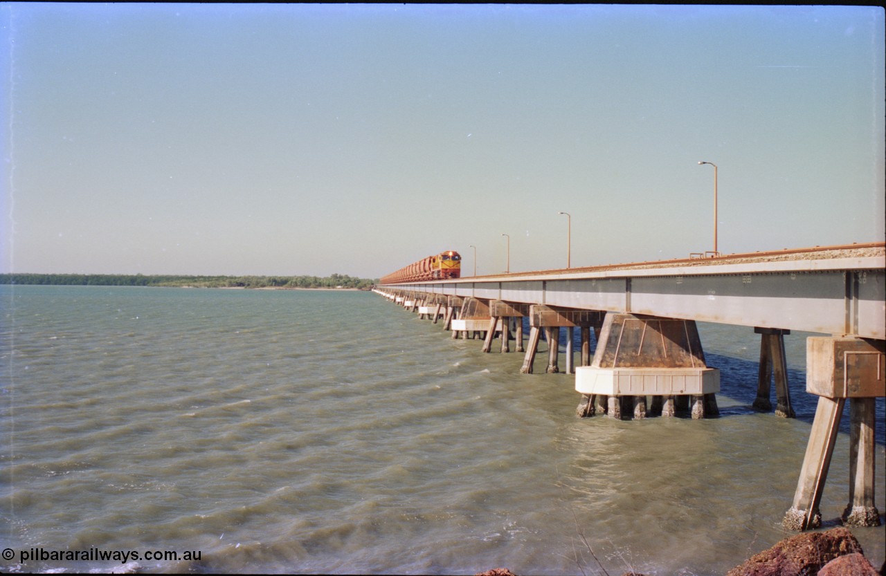 212-29
Weipa, Mission River road and rail bridge from the Andoom and rail side with an empty train headed by Comalco unit R 1004 purchased off BHP Iron Ore in 1994 is a Clyde Engineering built EMD model JT42C built in 1990 with serial 90-1277. July 1995.
Keywords: R1004;Clyde-Engineering-Kelso-NSW;EMD;JT26C;90-1277;Comalco;GML10;Cinderella;GML-class;