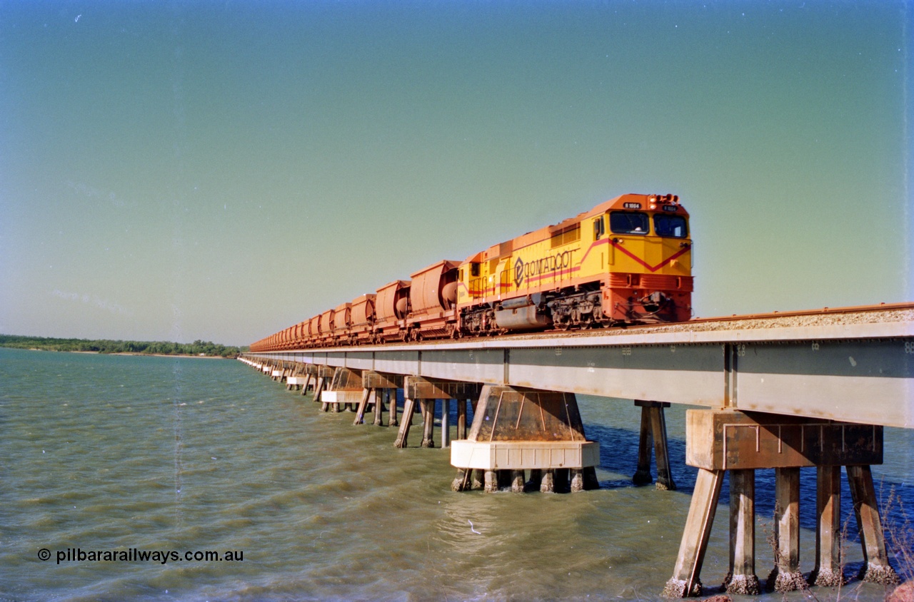 212-30
Comalco unit R 1004 purchased off BHP Iron Ore in 1994 is a Clyde Engineering built EMD model JT42C built in 1990 with serial 90-1277 leading an empty towards Andoom across the Mission River Bridge at high tide. July 1995.
Keywords: R1004;Clyde-Engineering-Kelso-NSW;EMD;JT26C;90-1277;Comalco;GML10;Cinderella;GML-class;