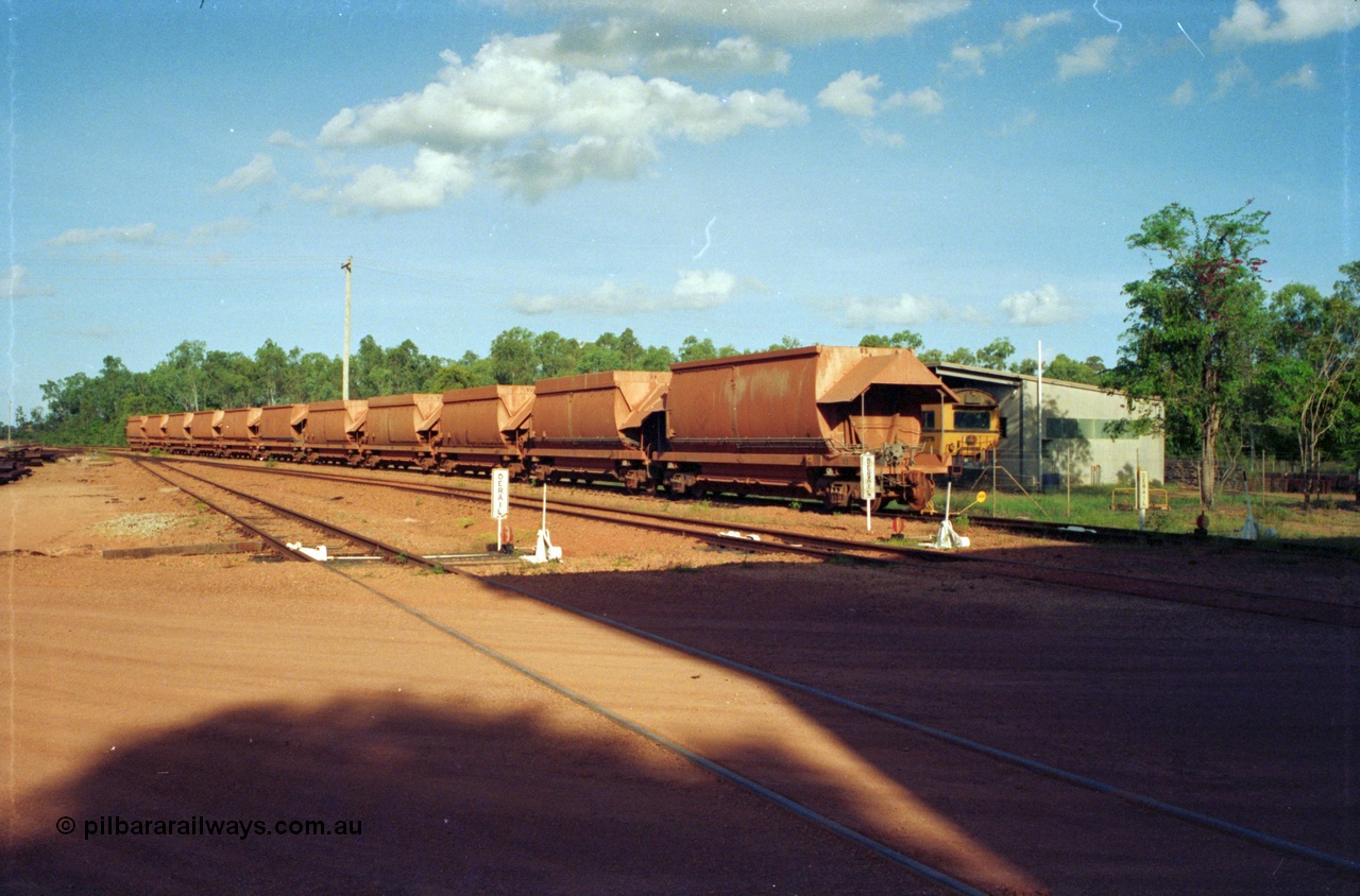 213-00
Weipa, Lorim Point Workshops looking east across to the track maintenance compound with eleven Comalco ore waggons of both types lined up and the Speno rail grinder in the compound, September 1995.
