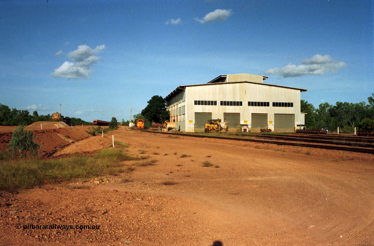 213-16
Weipa, Lorim Point workshops building, looking south east at the rear of the building and yard. From the left, R 1003, waggons, R 1001 and the Canron Rail Group Mk I switch tamper.
