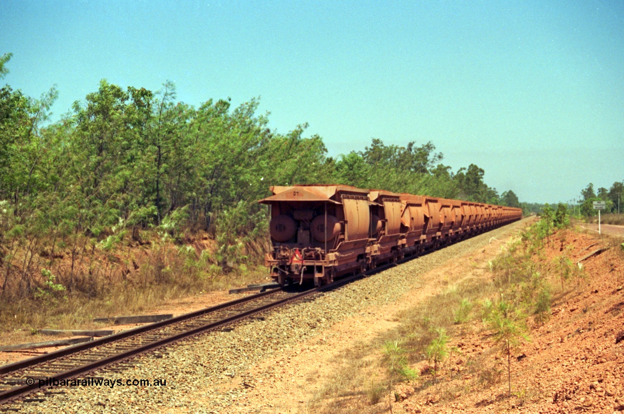 213-35
Weipa, trailing view of a loaded train from Andoom near Northern Avenue with Comalco R 1004 out of site leading thirty three loaded waggons of bauxite.
Keywords: R1004;Clyde-Engineering-Kelso-NSW;EMD;JT26C;90-1277;Comalco;GML10;Cinderella;GML-class;