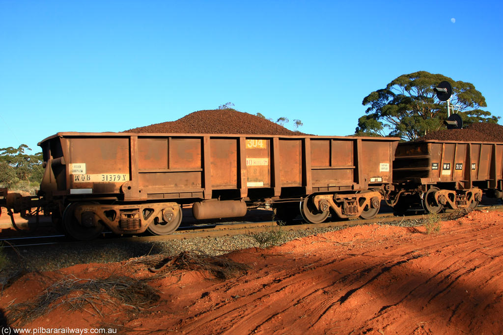 100731 02346
WOB type iron ore waggon WOB 31379 is one of a batch of twenty five built by Comeng WA between 1974 and 1975 and converted from Mt Newman high sided waggons by WAGR Midland Workshops with a capacity of 67 tons with fleet number 304 for Koolyanobbing iron ore operations, the WAGR and Comeng builders plates are visible in the waggon sill, on loaded train 6413 at Binduli Triangle, 31st July 2010.
Keywords: WOB-type;WOB31379;Comeng-WA;Mt-Newman-Mining;