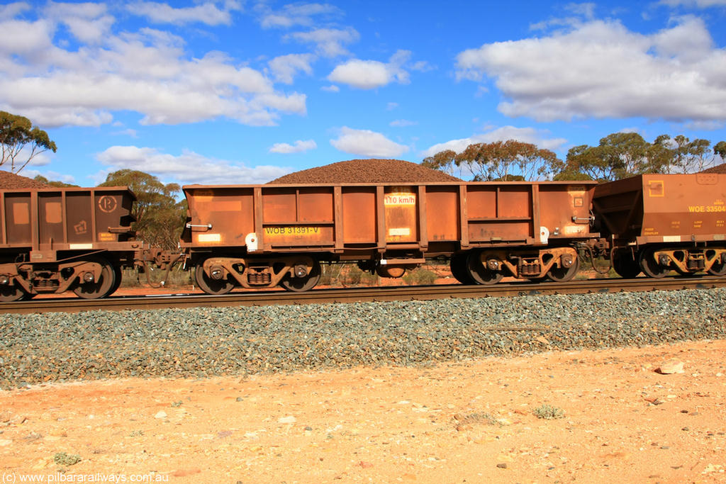 100731 02896
WOB type iron ore waggon WOB 31391 is one of a batch of twenty five built by Comeng WA between 1974 and 1975 and converted from Mt Newman high sided waggons by WAGR Midland Workshops with a capacity of 67 tons with fleet number 316 for Koolyanobbing iron ore operations. This waggon was also converted to a WSM type ballast hopper by re-fitting the cut down top section and having bottom discharge doors fitted, converted back to WOB in 1998, on loaded train 7415 at Binduli Triangle, 31st July 2010.
Keywords: WOB-type;WOB31391;Comeng-WA;WSM-type;Mt-Newman-Mining;