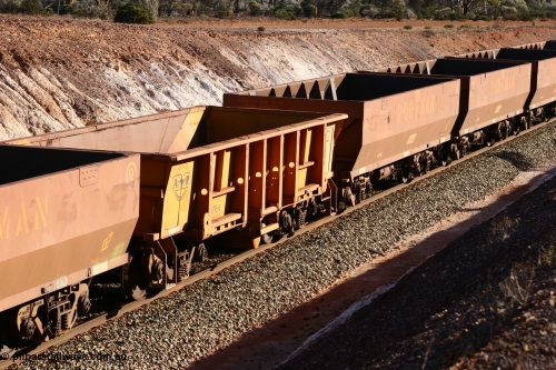 060528 4615
WOB type iron ore waggon WOB 31395 is one of a batch of twenty five built by Comeng WA between 1974 and 1975 and converted from Mt Newman high sided waggons by WAGR Midland Workshops with a capacity of 67 tons with fleet number 325 for Koolyanobbing iron ore operations. This waggon was also converted to a WSM type ballast hopper by re-fitting the cut down top section and having bottom discharge doors fitted, converted back to WOB in 1997, and this is the first one to be repainted in ARG yellow and stands out against the newer style WOE type waggons as this empty train runs past the 628 km west of Bonnie Vale, May 28, 2006.
Keywords: WOB-type;WOB31395;Comeng-WA;WSM-type;Mt-Newman-Mining;