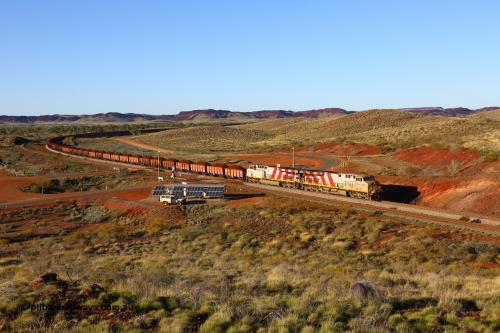180616 1635
Harding Siding, a loaded train from Mesa A behind double Rio Tinto loco 9103 with serial 61941 a GE Erie built GE model ES44ACi from the 1st order in Rio Tinto Stripes livery and 9108 serial 62539 with 167 'J' type ore waggons rounds the curve at the 38.5 km grade crossing. 16th June 2018. [url=https://goo.gl/maps/JKiinSDiquy]GeoData[/url]
Toad Montgomery image.
Keywords: 9103;GE;ES44ACi;61941;Rio-Tinto-Stripes;