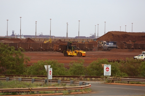 150523 8234
Nelson Point Yard, I Area, waggon scrapping by Sims Metal, a fork lift carries waggon no. 3340, one of 350 waggons built in Romania of which only about 60 made it into service, the rest rusting away in a caged embargo area out on the Broome Road until they were scrapped some years ago. There is a connection with these waggons and Lang Hancock and his former mine McCamey's Monster, now known as Jimblebar. 5665 looks on, its days also numbered.
Keywords: Astra-Vagoane-Arad-Romania;BHP-ore-waggon;