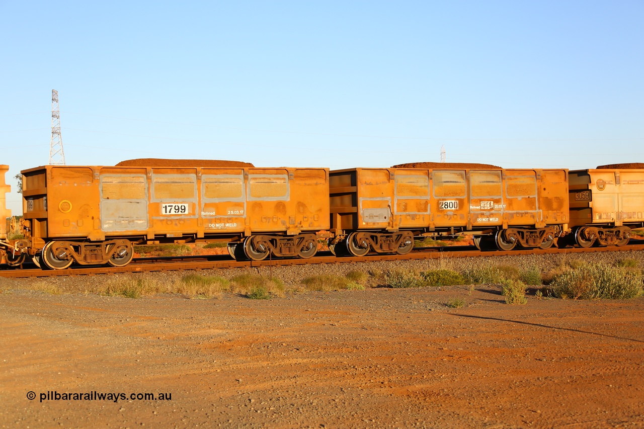 170726 9457
Boodarie, FMG ore waggon pair 2800 (control) and 1799 (slave) of the original design and loaded with fines ore shows evidence of side wall panel replacement and new relining dates. 26th July 2017.
