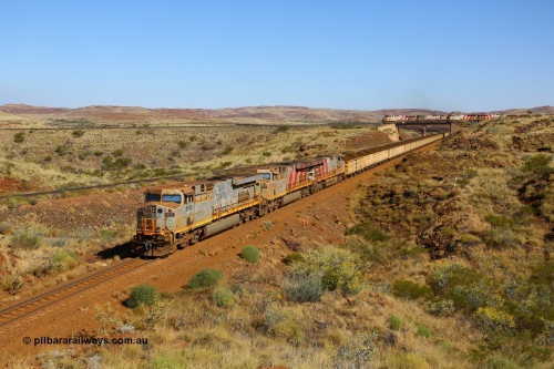 170728 09855
Western Creek - Emu area, Rio Tinto's General Electric built ES44DCi class leader 8100 serial 57996 leads two sister units, in 8176 and 8143 both in the later Rio Tinto stripe livery, with a loaded train running down from Emu Siding on the line to Dampier. The disabled Mesa A train is still on the bridge, the line to the left of the loaded is the Robe River Western Creek - Emu interconnecting line. 28th July 2017. [url=https://goo.gl/maps/vvUWXEgppNM2]GeoData[/url].
Keywords: 8100;GE;ES44DCi;57996;