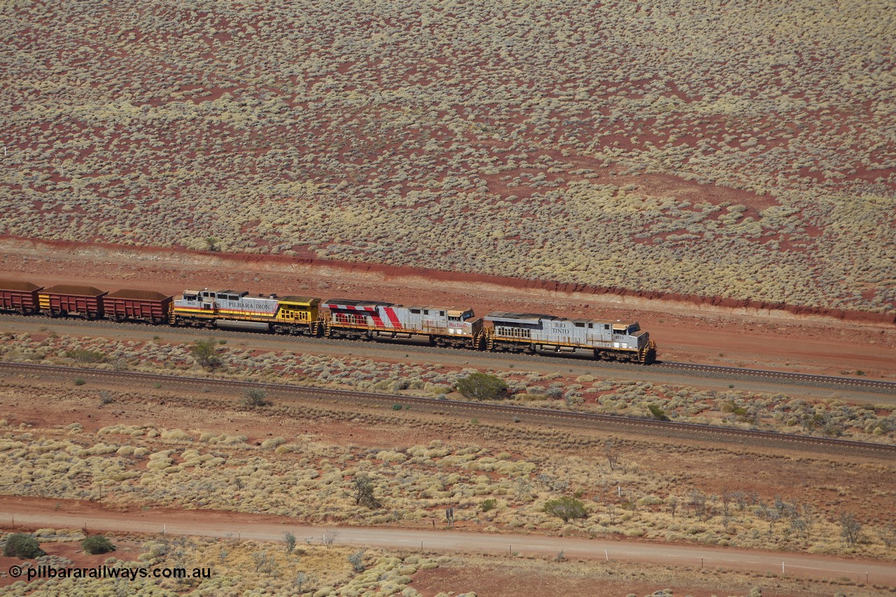 151111 9520
A loaded train behind General Electric ES44DCi units 8113 serial 59105 in the original silver livery and 8145 serial 58726 in the tiger strip Rio livery and Dash 9-44CW 9433 serial 54766 in ROBE Pilbara Iron livery runs along on the West Mainline bound for Cape Lambert viewed from Table Hill.
Keywords: 8113;GE;ES44DCi;59105;