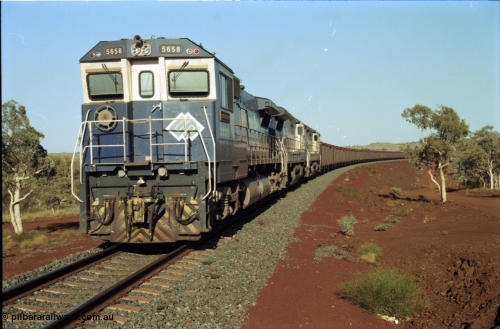 196-11
Yandi Two loaded car side of the loadout balloon loop, BHP Iron Ore CM40-8M or Dash 8 motive power in the form of 5658 'Kakogawa' serial 8412-03 / 94-149 rebuilt by Goninan as GE model CM40-8M from ALCo M636C number 5480 and two new Goninan built GE CM39-8 units 5630 'Zeus' serial 5831-09 / 88-079 and 5631 'Apollo' serial 5831-10 / 88-080 are the head end power with another two CM40-8M units mid-train. Train length is 240 waggons with a 120/120 split. Yandi Two ore stockpile and pedestal stacker boom tip visible in the background, the loadout operates via gravity and the train travels through a tunnel. May 1998.
Keywords: 5658;Goninan;GE;CM40-8M;8412-03/94-149;rebuild;AE-Goodwin;ALCo;M636C;5480;G6061-1;