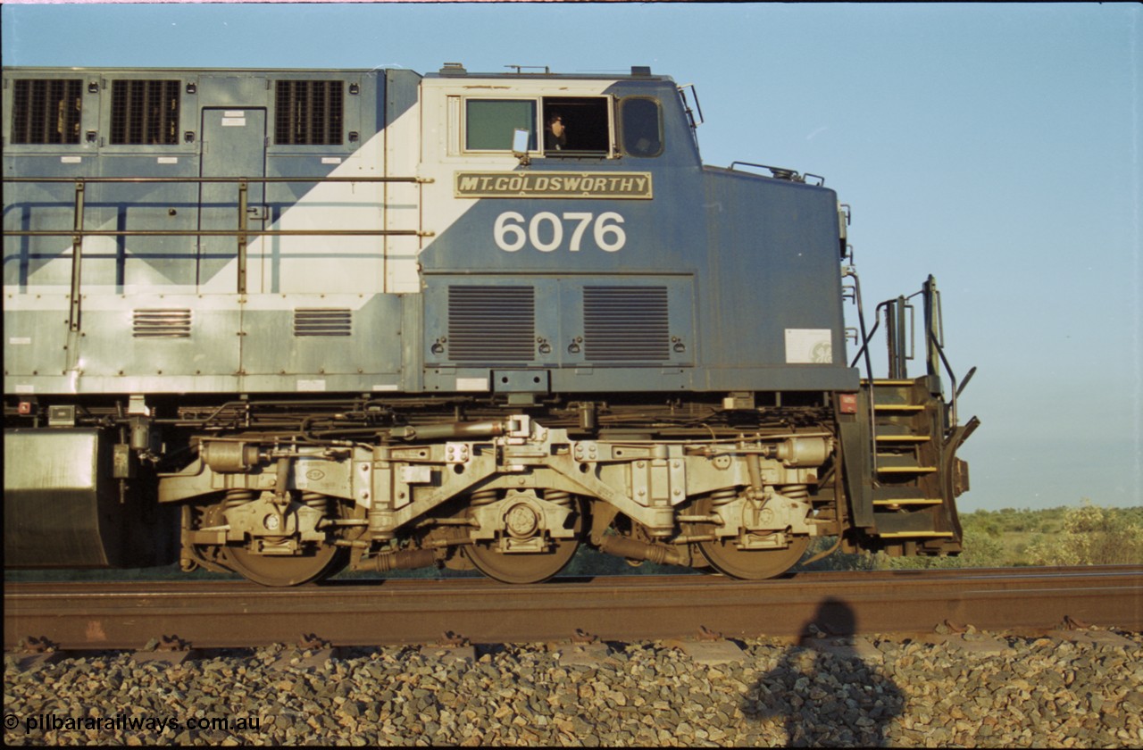 203-12
Bing Siding, BHP Iron Ore General Electric AC6000 model 6076 'Mt Goldsworthy' serial 51068 with an empty train. Cab side view with name board, steerable bogie and Driver Cosgrove at the controls.
Keywords: 6076;GE;AC6000;51068;