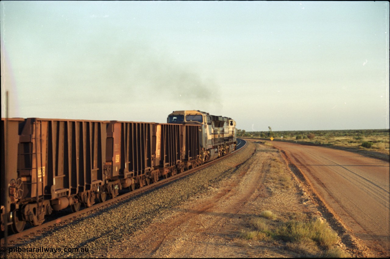 203-22
Bing Siding, empty train behind a pair of General Electric AC6000 units powers around the curve. Note the ladder on the original Comeng style waggon.
