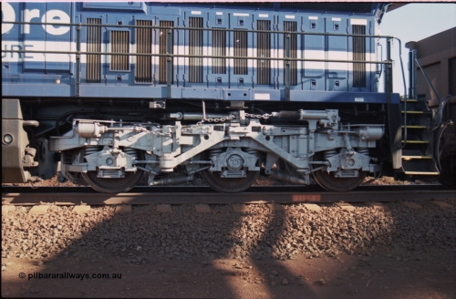 207-13
BHP General Electric built AC6000 unit 6074 serial 51066, brand new and unnamed at Yandi One load-out loop as a remote mid-train unit view of left hand side rear steerable bogie and air intakes below radiator.
Keywords: 6074;GE;AC6000CW;51066;
