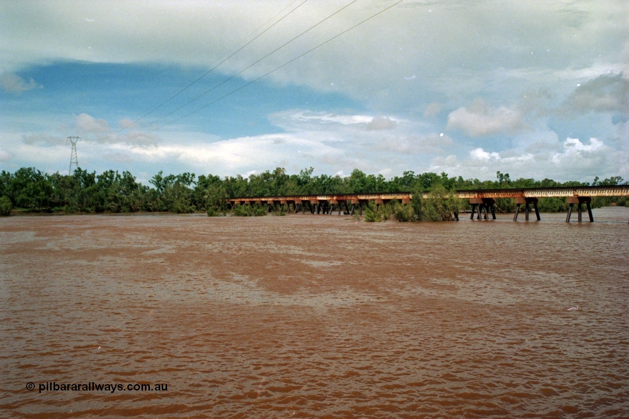 218-05
De Grey River Bridge, former road and rail, now only rail bridge for the Goldsworthy line, looking east, river is in flood, wide angle view.
