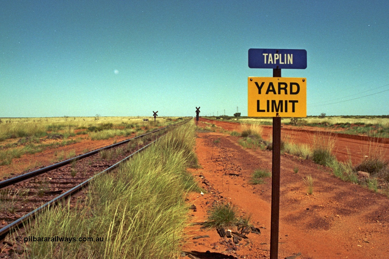 220-05
Taplin Siding, located between the 135 and 137.5 km on the former Goldsworthy Mining Ltd line, now part of the BHP Iron Ore network looking west past the Yard Limit sign and the 137.5 km grade crossing.
