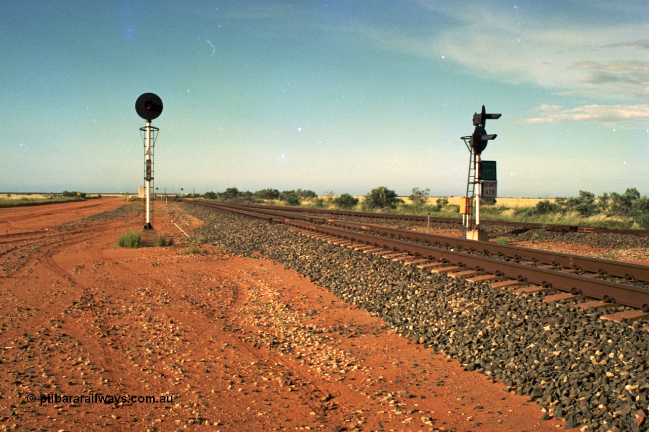 220-26
Goldsworthy Junction, an empty train on the Newman line approaches having departed Nelson Point. The line merging in from the right is the Goldsworthy line to Yarrie and Nimingarra, which can then be made out diverging to the left just after the interlocking room in front of the train.
